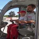 Unser Lagerplatzleiter beim Minibagger fahren mit einem kleinen süßen Mädchen bei der Kinderbaustelle im Zuge der Gemeindesommeraktivitäten 2015